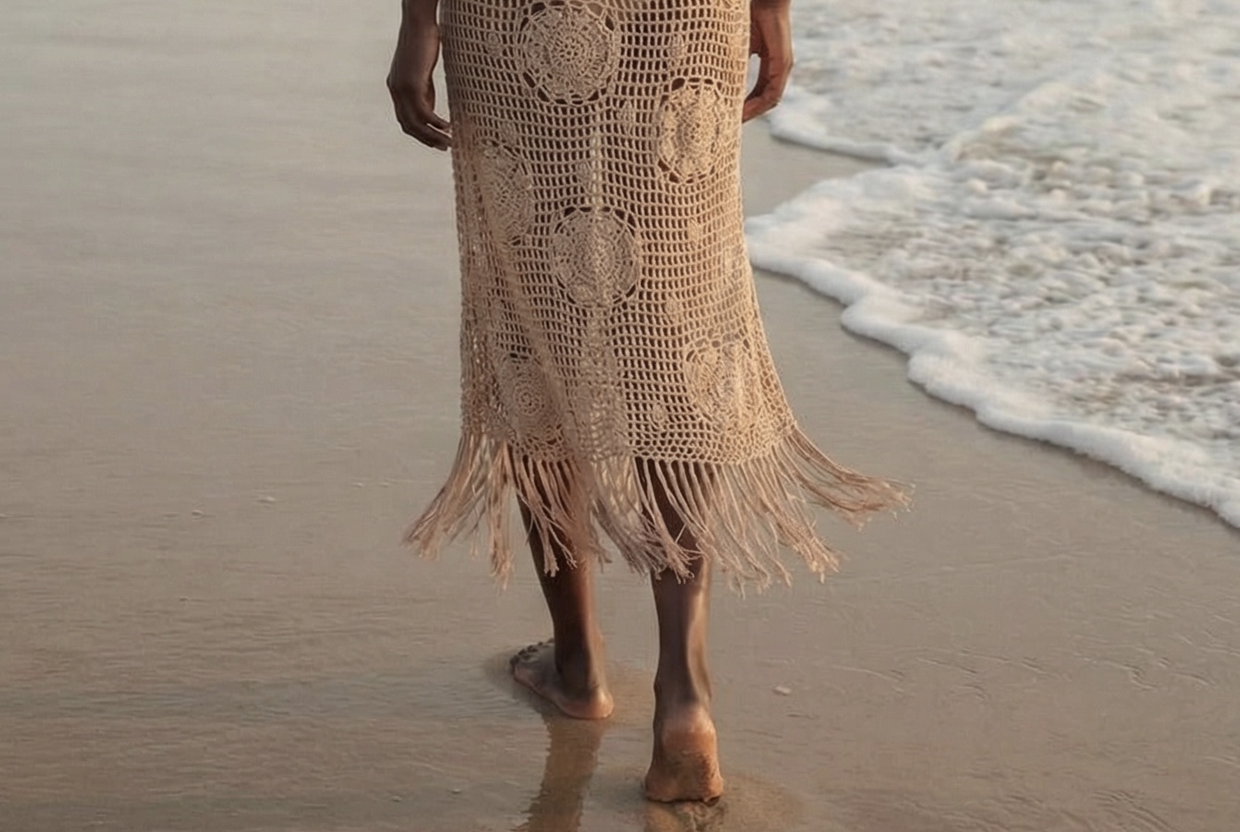 Woman wearing a handmade crochet resort dress by the sea
